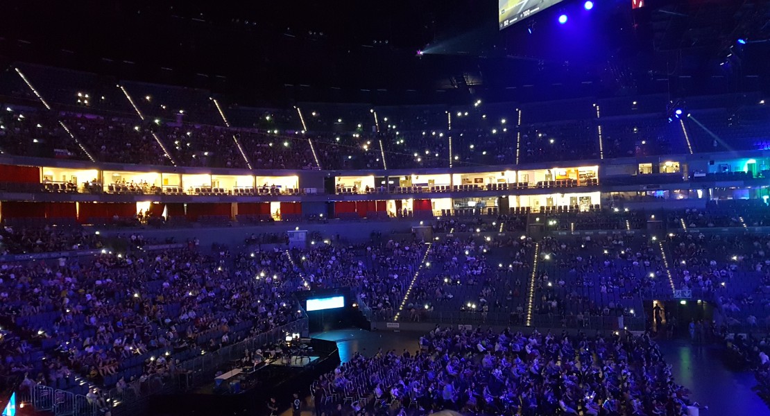 Crowd holding up their phone screens during an interval between matches or map change.